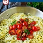 An image of a skillet of his angel hair pasta which is tender noodles coated in garlic, fresh herbs, olive oil, butter and parmesan cheese.