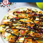 A picture of apple nachos which are sliced apples topped with caramel, chocolate and plenty of other fun toppings.