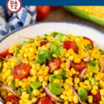 A bowl of avocado corn salad which is a blend of corn kernels, fresh avocado, ripe tomatoes and red onion, all tossed in a homemade lime dressing.