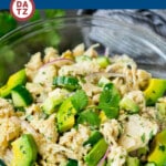 A bowl of avocado tuna salad which is loaded with chunks of tuna, avocado and colorful veggies.