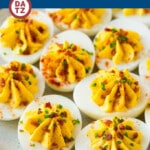 A plate of bacon deviled eggs which are a classic recipe dressed up with the addition of bacon bits and chives.