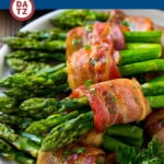A plate of bacon wrapped asparagus which is an easy yet elegant side dish that's sure to garner rave reviews!