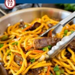 A pan of beef lo mein which is stir fried steak and vegetables tossed with egg noodles in a savory sauce.