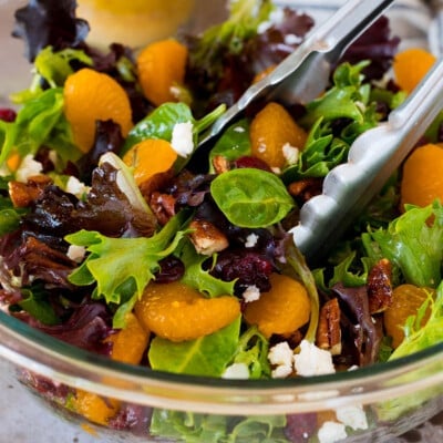 Tongs in a bowl of mandarin orange salad.