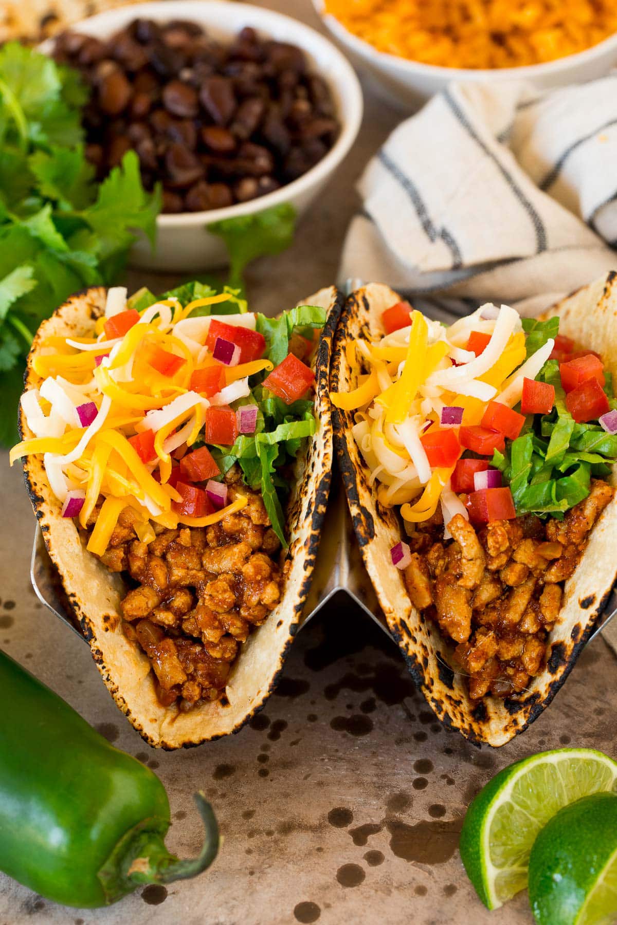 Turkey tacos in flour tortillas topped with lettuce, cheese and tomato.