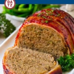 A plate of bacon wrapped meatloaf which is ground beef mixed with breadcrumbs and seasonings then covered in bacon slices and baked.