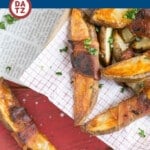 Several bacon wrapped potato wedges which are Russet potatoes wrapped in bacon, then roasted to crispy brown perfection.