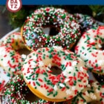 A plate of baked donuts which are soft and fluffy cake donuts coated in chocolate frosting then topped with festive sprinkles.