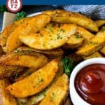 A plate of baked potato wedges which are coated in seasonings and cooked in the oven to golden brown perfection.