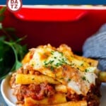A plate of baked ziti which is pasta with meat sauce and three types of cheese, all cooked together to golden brown perfection.