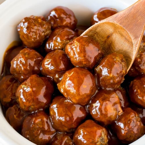 Crockpot BBQ meatballs in a slow cooker with a serving spoon.