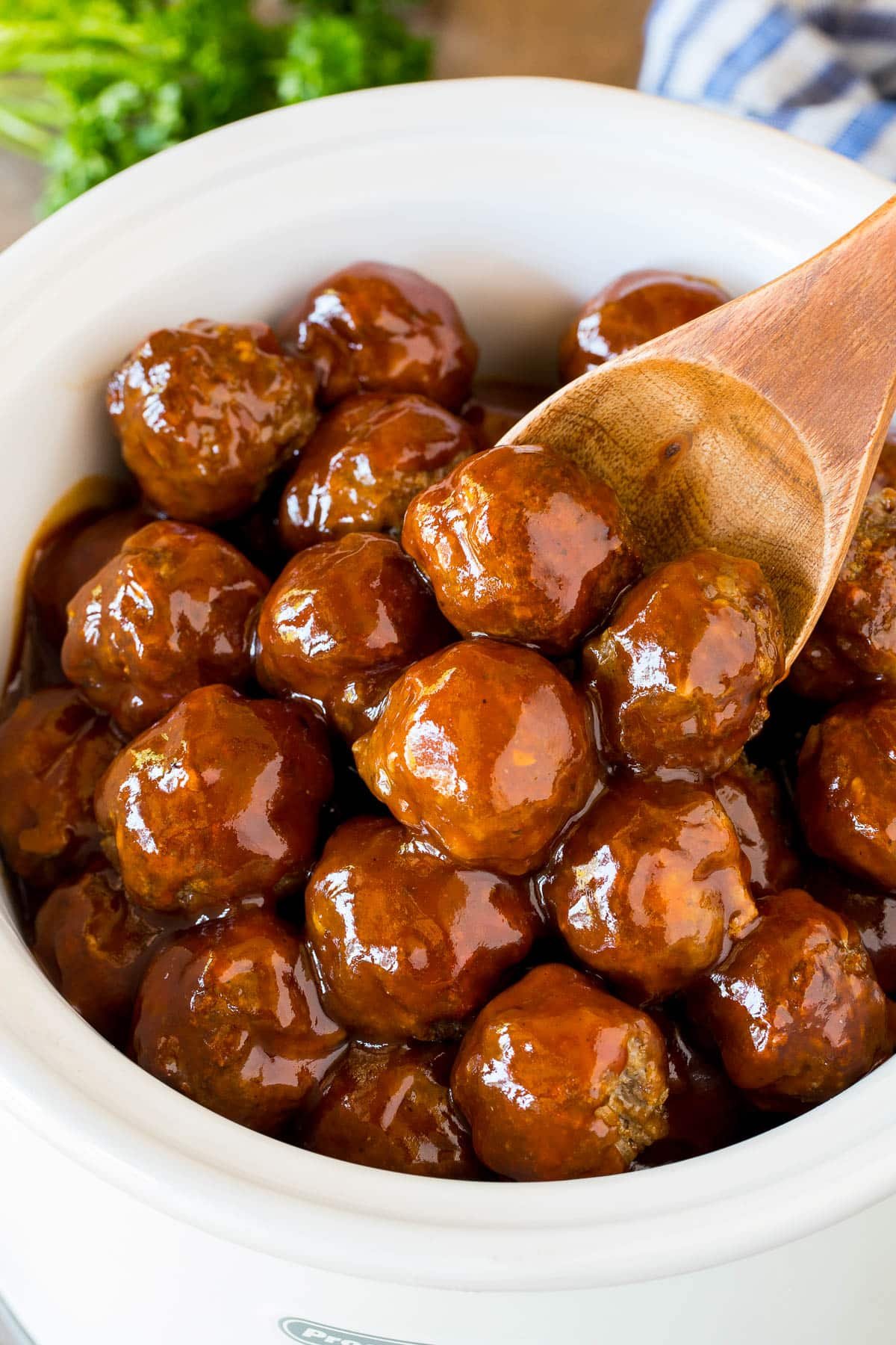 Crockpot BBQ meatballs in a slow cooker with a serving spoon.