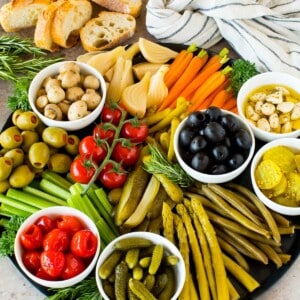 A relish tray filled with pickles, fresh vegetables and marinated veggies.