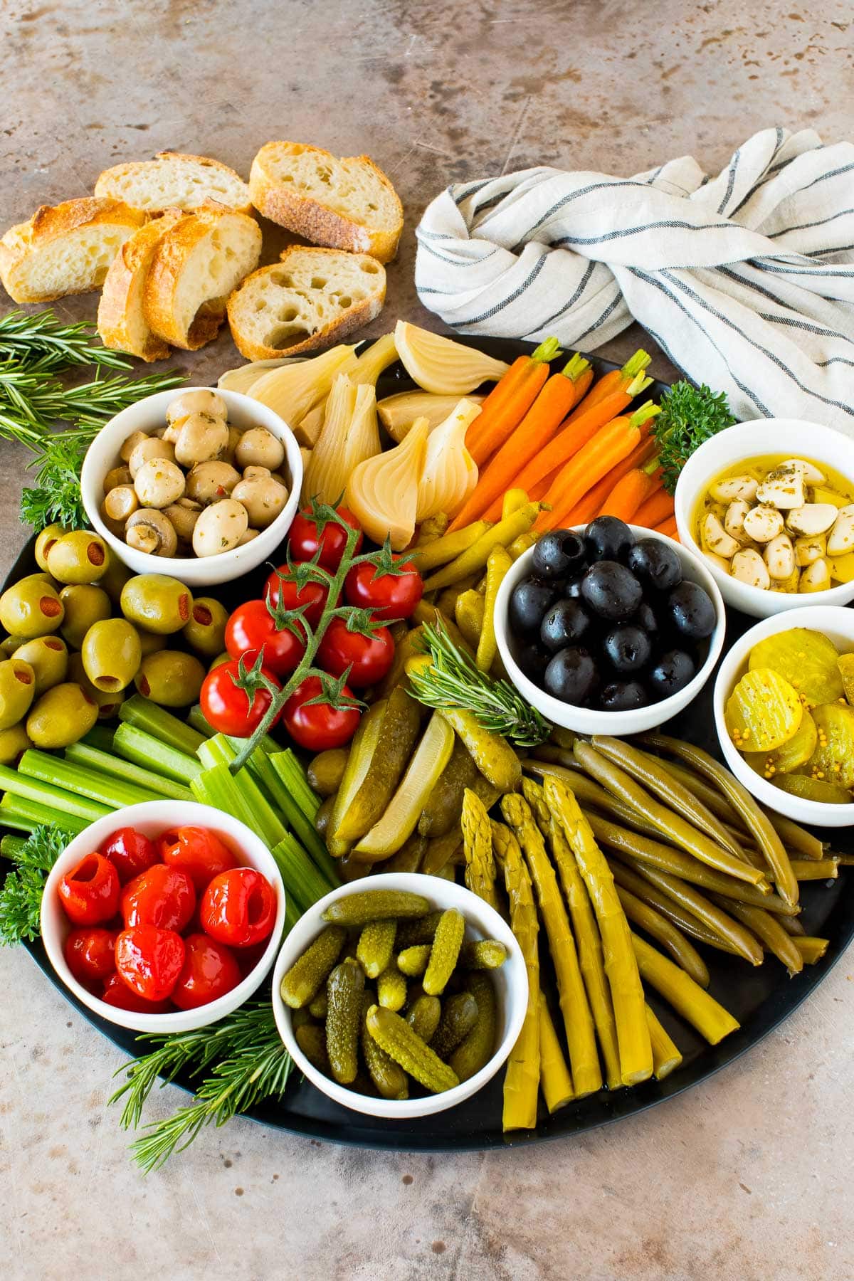 A relish tray filled with pickles, fresh vegetables and marinated veggies.