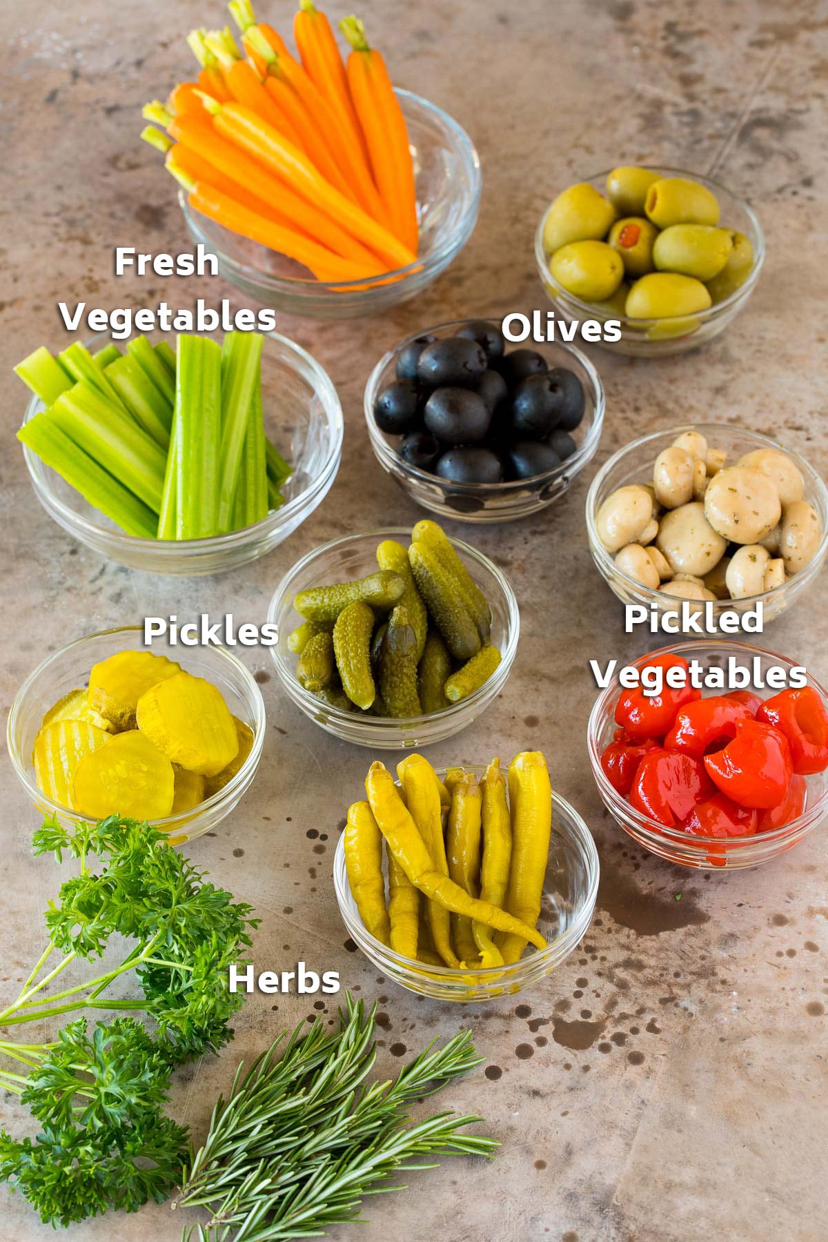 Bowls of olives, fresh veggies, pickles and marinated vegetables.