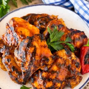 BBQ chicken marinade on chicken thighs that have been grilled and are on a platter.