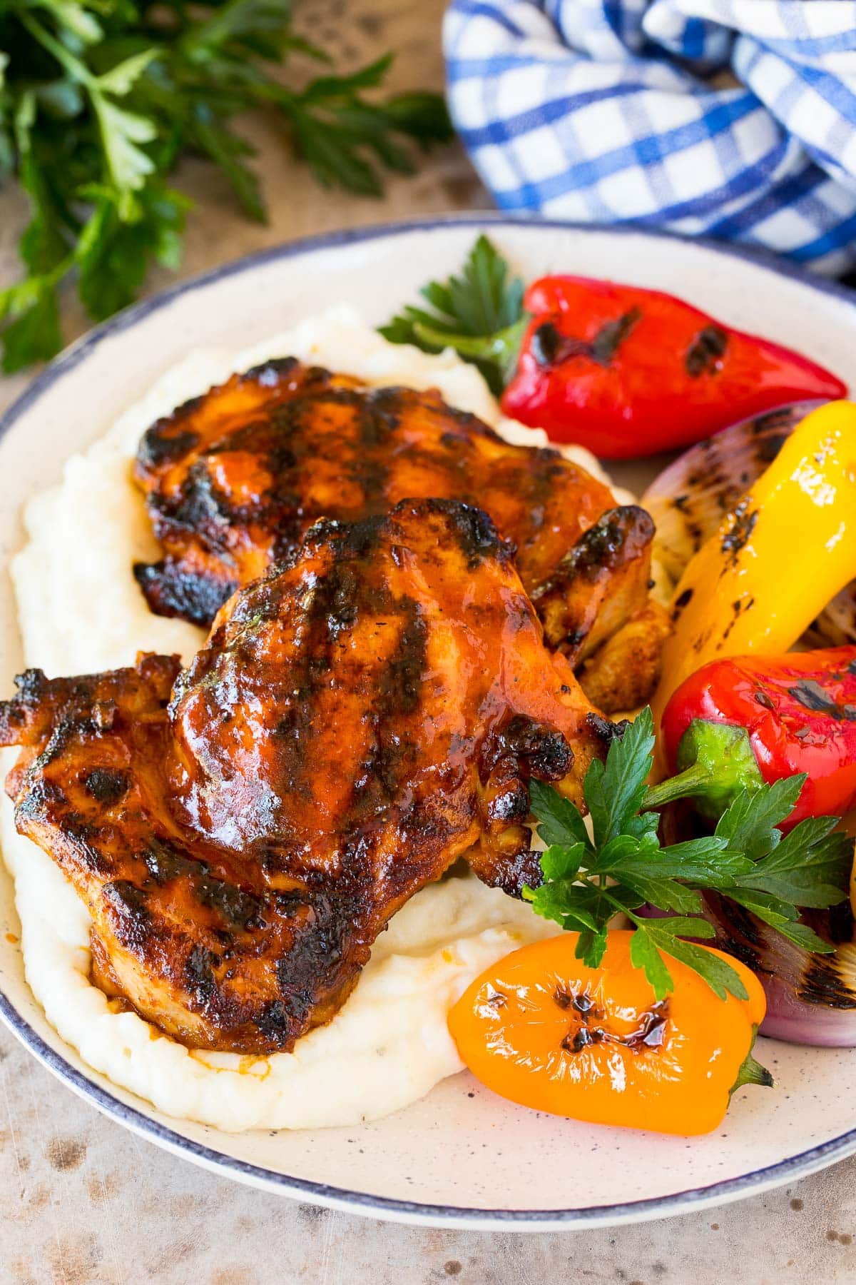 Thighs coated in BBQ chicken marinade grilled and served with mashed potatoes and peppers.