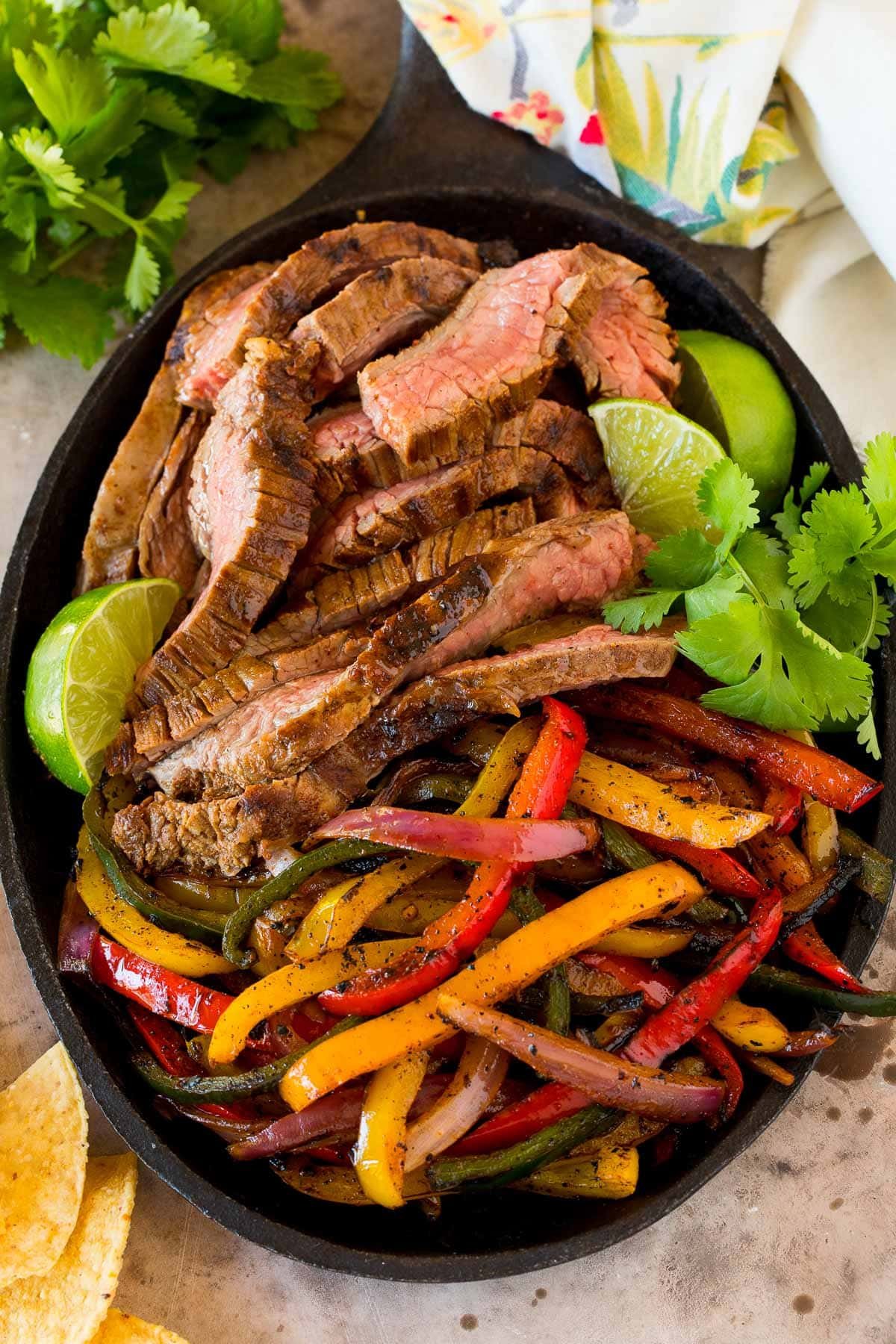 Steak fajita marinade coated meat and peppers in a cast iron pan.