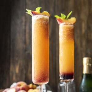 A picture of two frozen peach Bellinis in tall glasses.