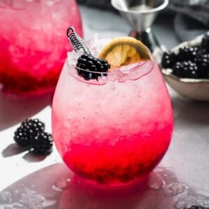 A picture of a blackberry bramble drink on a table.