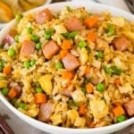 A serving bowl of ham fried rice topped with green onions.