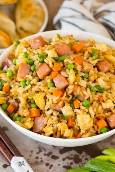 A serving bowl of ham fried rice topped with green onions.