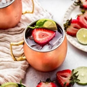 A picture of a copper mug with a strawberry Moscow mule.