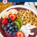 This quick and easy acai bowl recipe is a thick smoothie made with frozen fruit, acai puree and coconut milk that's served in a bowl and finished with a fun and colorful variety of toppings.