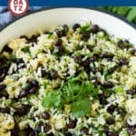 A pot of black beans and rice with a cilantro garnish on top.