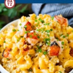 A bowl of lobster mac and cheese with chunks of tender lobster on top.
