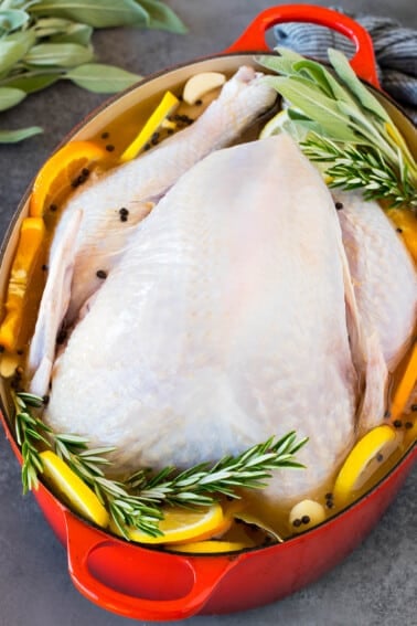 A raw turkey in a pot of smoked turkey brine.