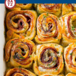 These hot ham and cheese pinwheels are rolls loaded with plenty of meat and swiss, then topped with a butter poppy seed sauce and baked to golden brown perfection.