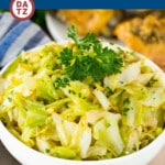 A bowl of sauteed cabbage garnished with parsley.
