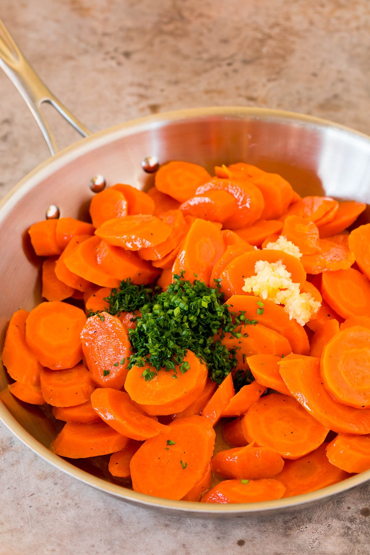 Carrots in a pan with garlic and herbs.