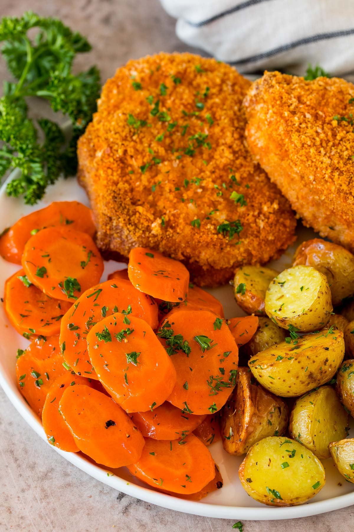 Sauteed carrots on a plate with pork chops, carrots and potatoes.