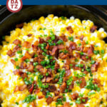 A pot of slow cooker creamed corn with crispy bacon and fresh chives on top.