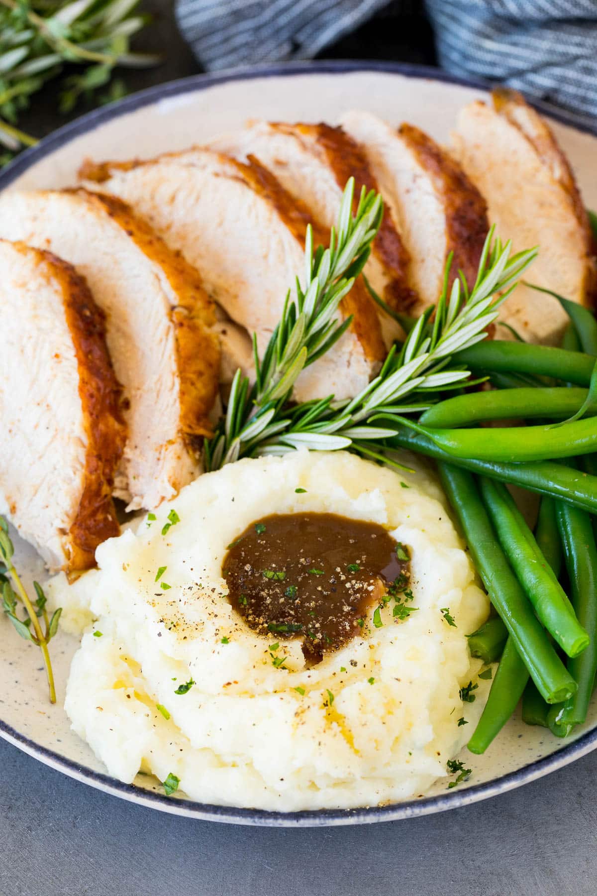 Sour cream mashed potatoes on a plate with turkey and green beans.