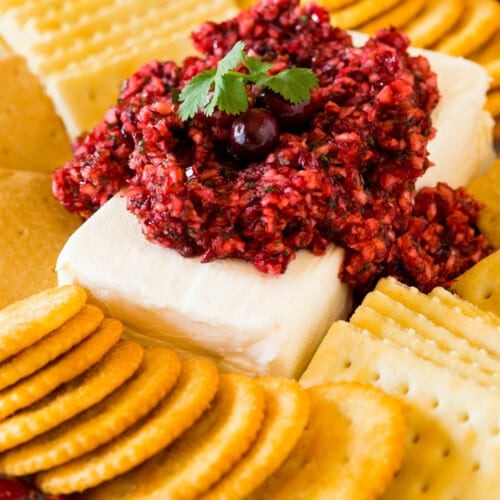 Cranberry jalapeno dip served on a block of cream cheese with crackers.