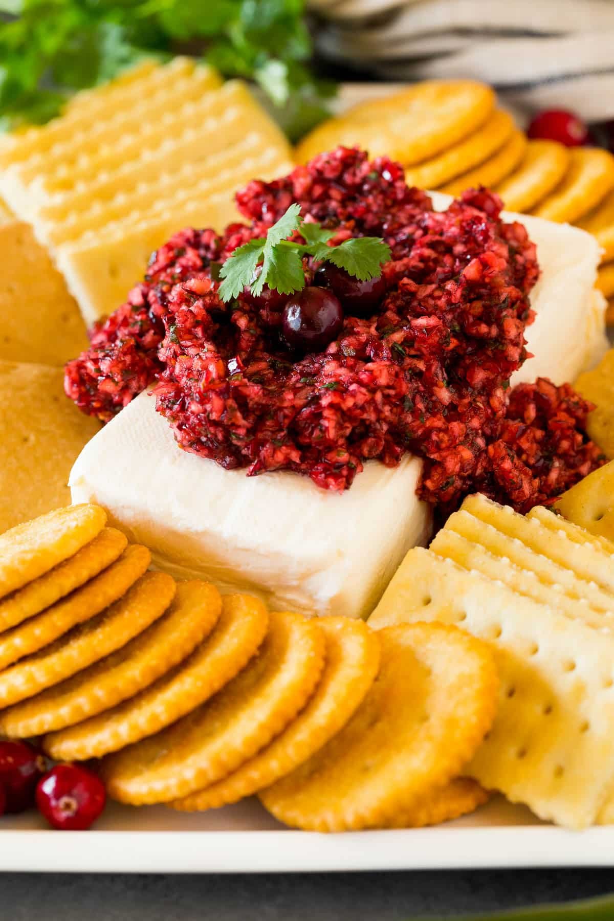 Cranberry jalapeno dip served on a block of cream cheese with crackers.