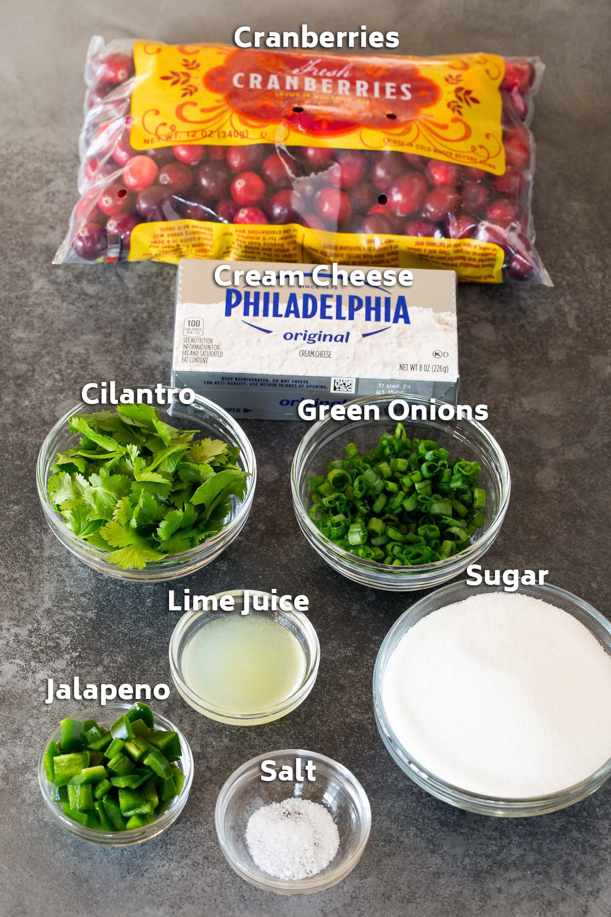 Ingredients including cranberries, cream cheese, cilantro, green onions and sugar.