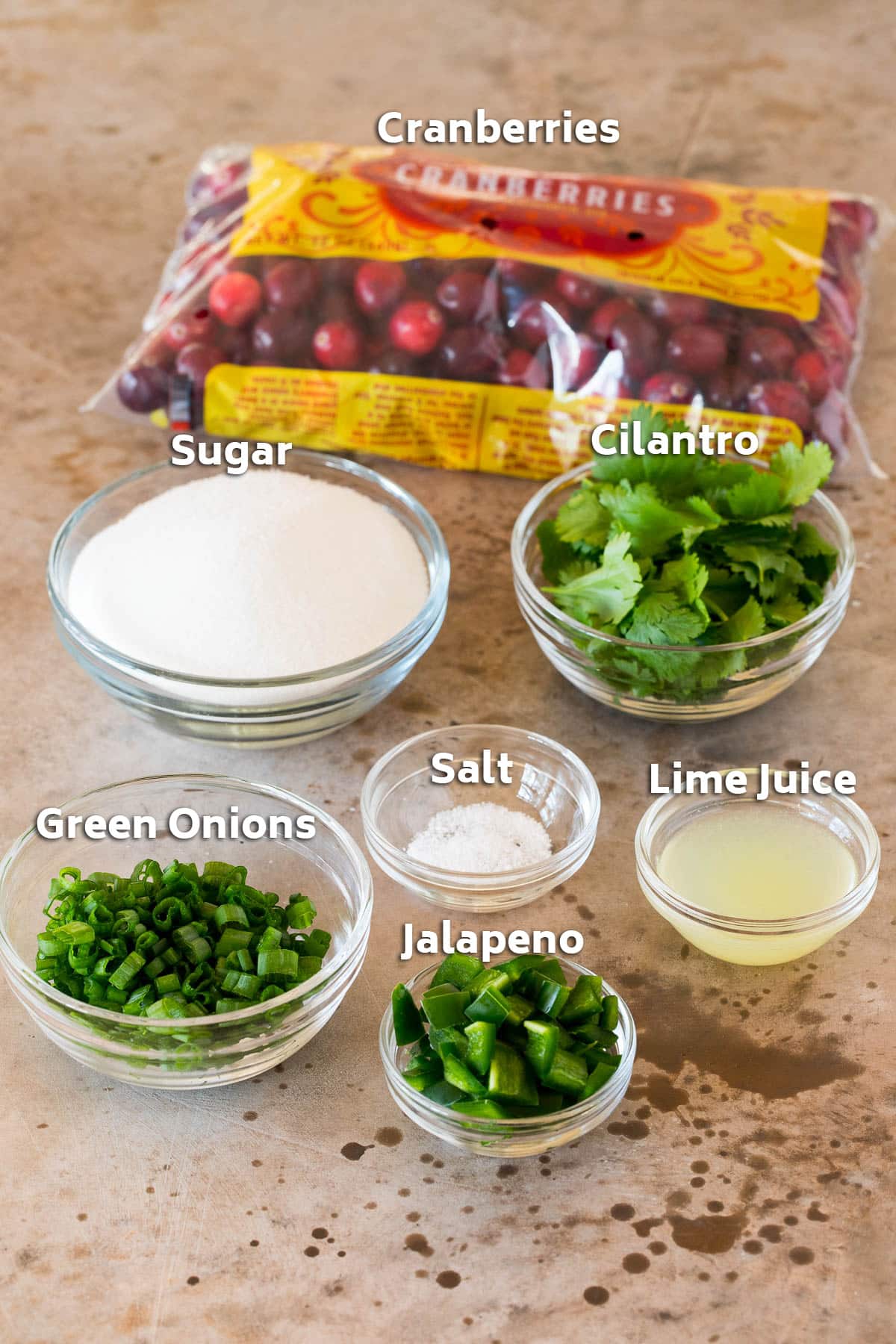 Ingredients including berries, lime juice, cilantro, green onions and sugar.