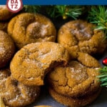 Several molasses cookies on a table with Christmas decorations.