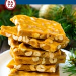 A stack of peanut brittle on a small plate.