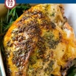 Roasted turkey breast in a baking dish garnished with herbs.