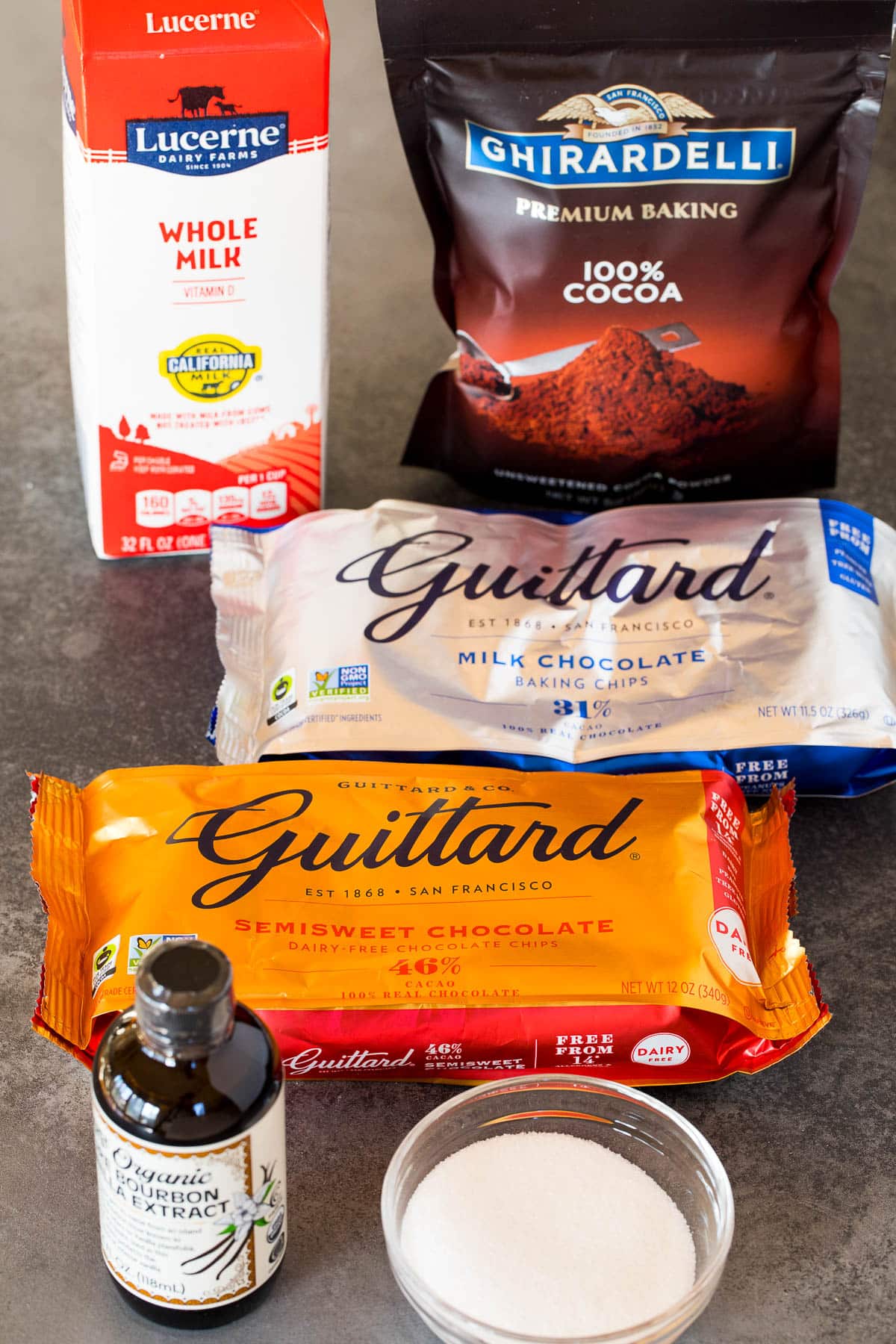 Hot cocoa ingredients including milk, chocolate, cocoa powder and sugar.