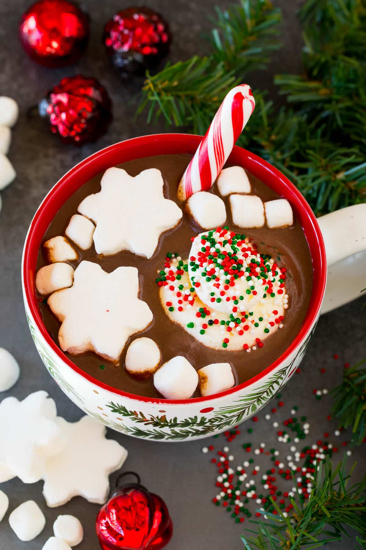 Christmas hot chocolate in a decorative mug with marshmallows and sprinkles on top.