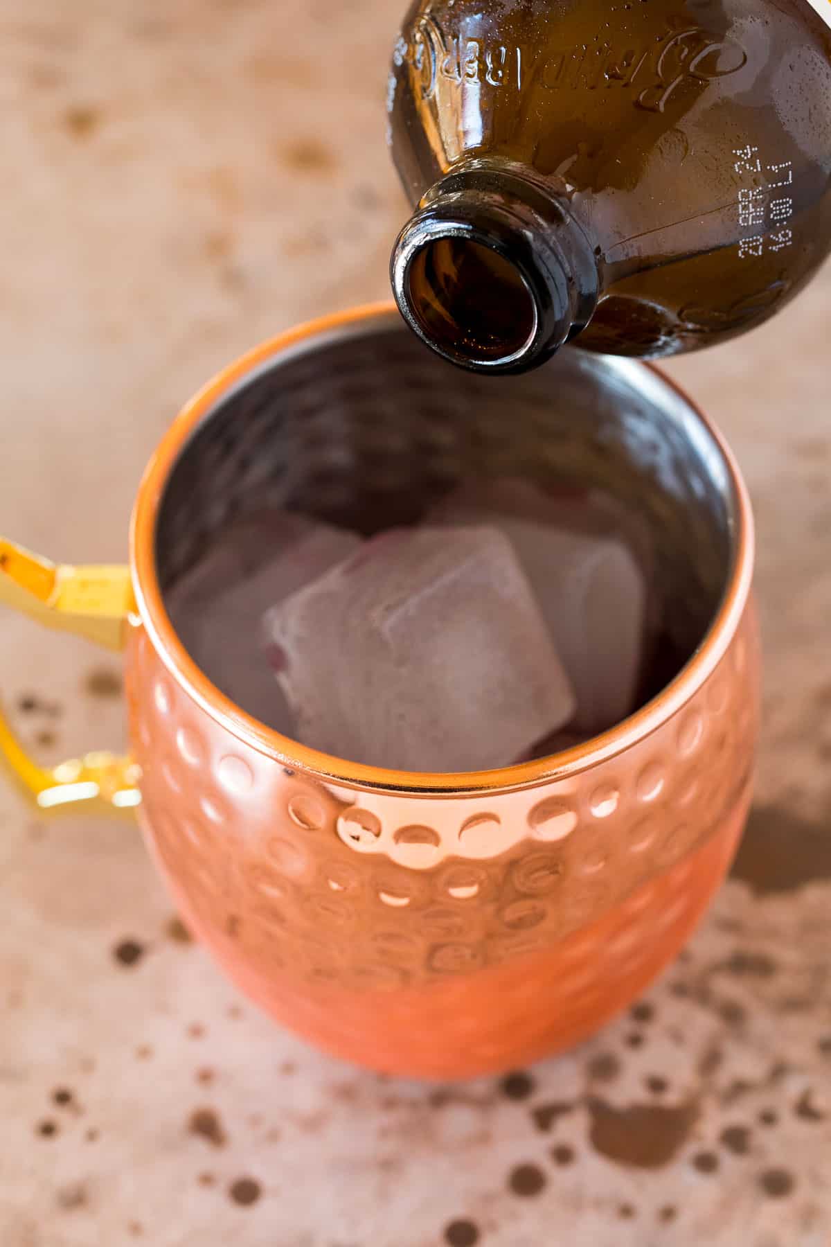 Ginger beer being poured into a mug.