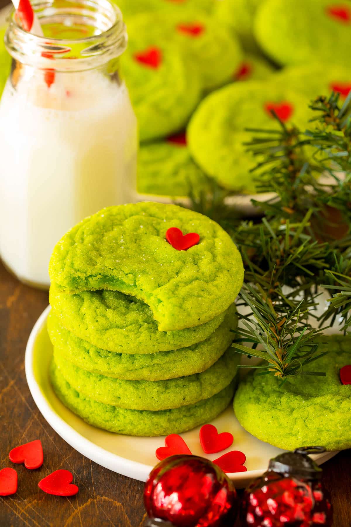 A stack of Grinch cookies with a bite taken out of one.