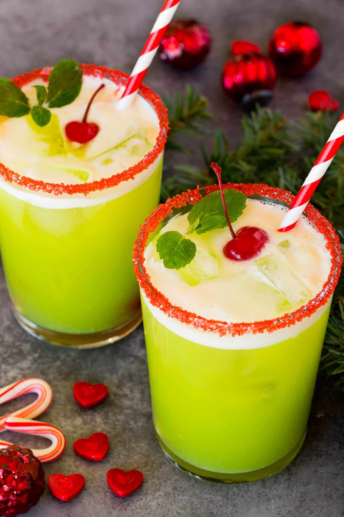 Cups of Grinch punch topped with cherries and mint sprigs.