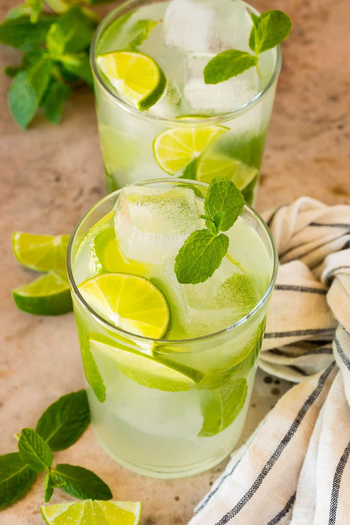 Two glasses of mojito mocktail made with mint, sugar, lime and club soda.